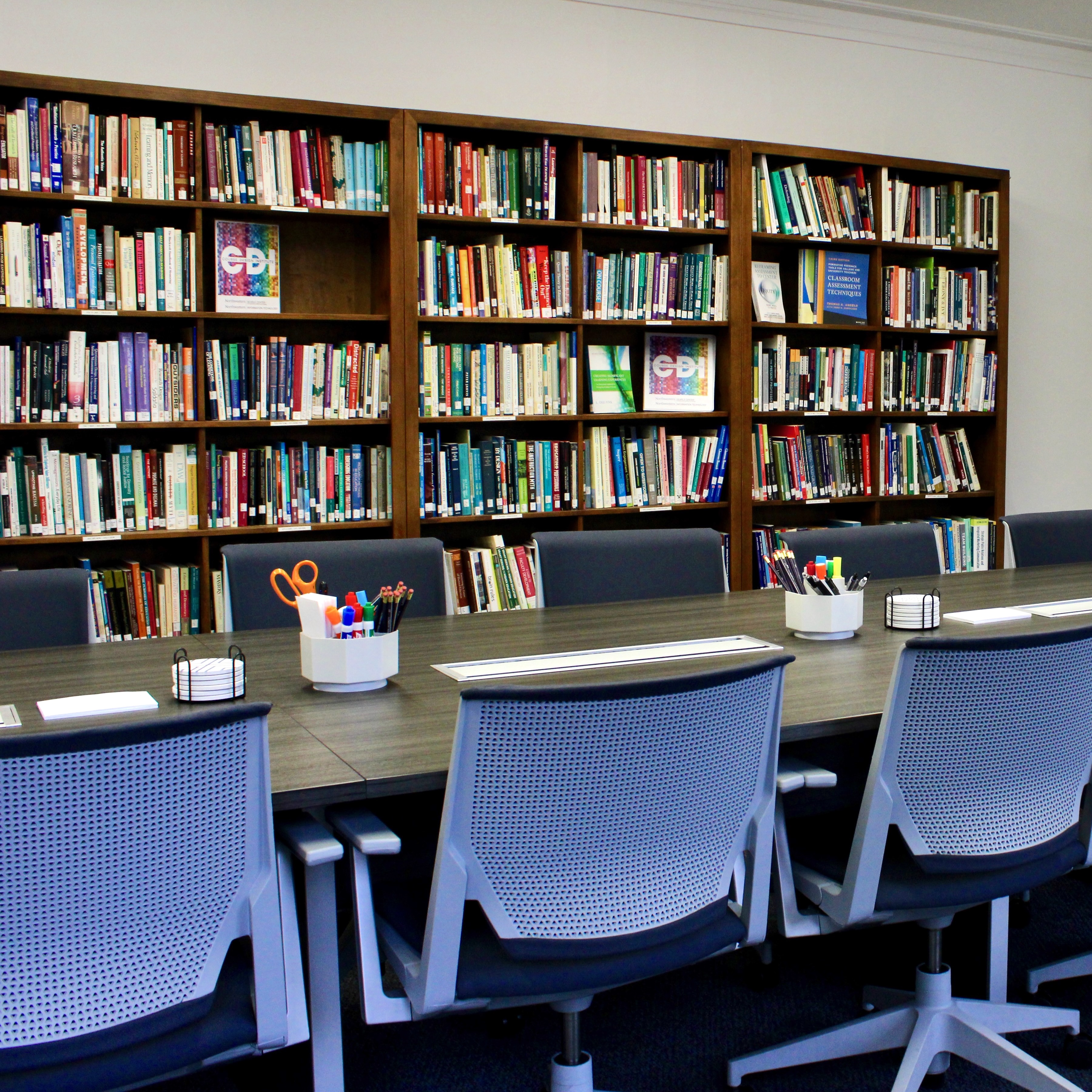 Photo of the Menges Library featuring bookshelves and a large conference table.
